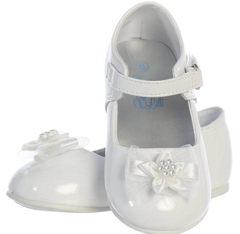 A pair of white shoes with bows on the front.