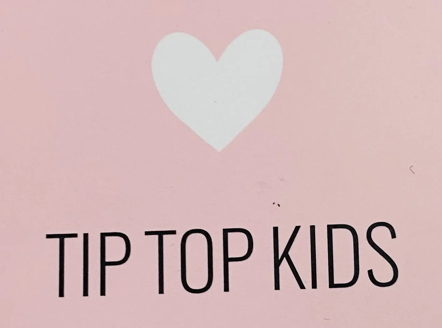 White heart above Tip Top Kids text